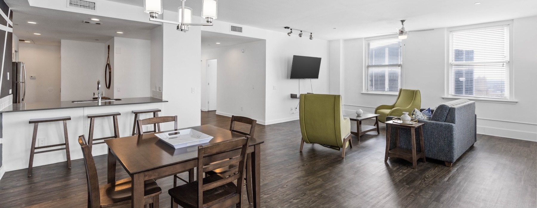 a living room and kitchen with tables, chairs, a couch and a tv